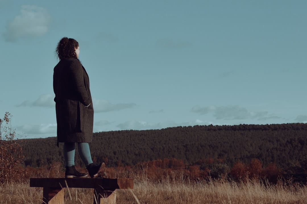 Photo by Tolu Akinyemi 🇳🇬 a woman standing on top of a wooden bench